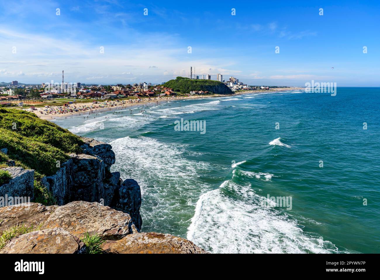 Spiaggia affollata e rocce in una bella giornata di sole, nell'estate della città di Torres sulla costa dello stato del Rio Grande do sul, Brasile, Brasile Foto Stock