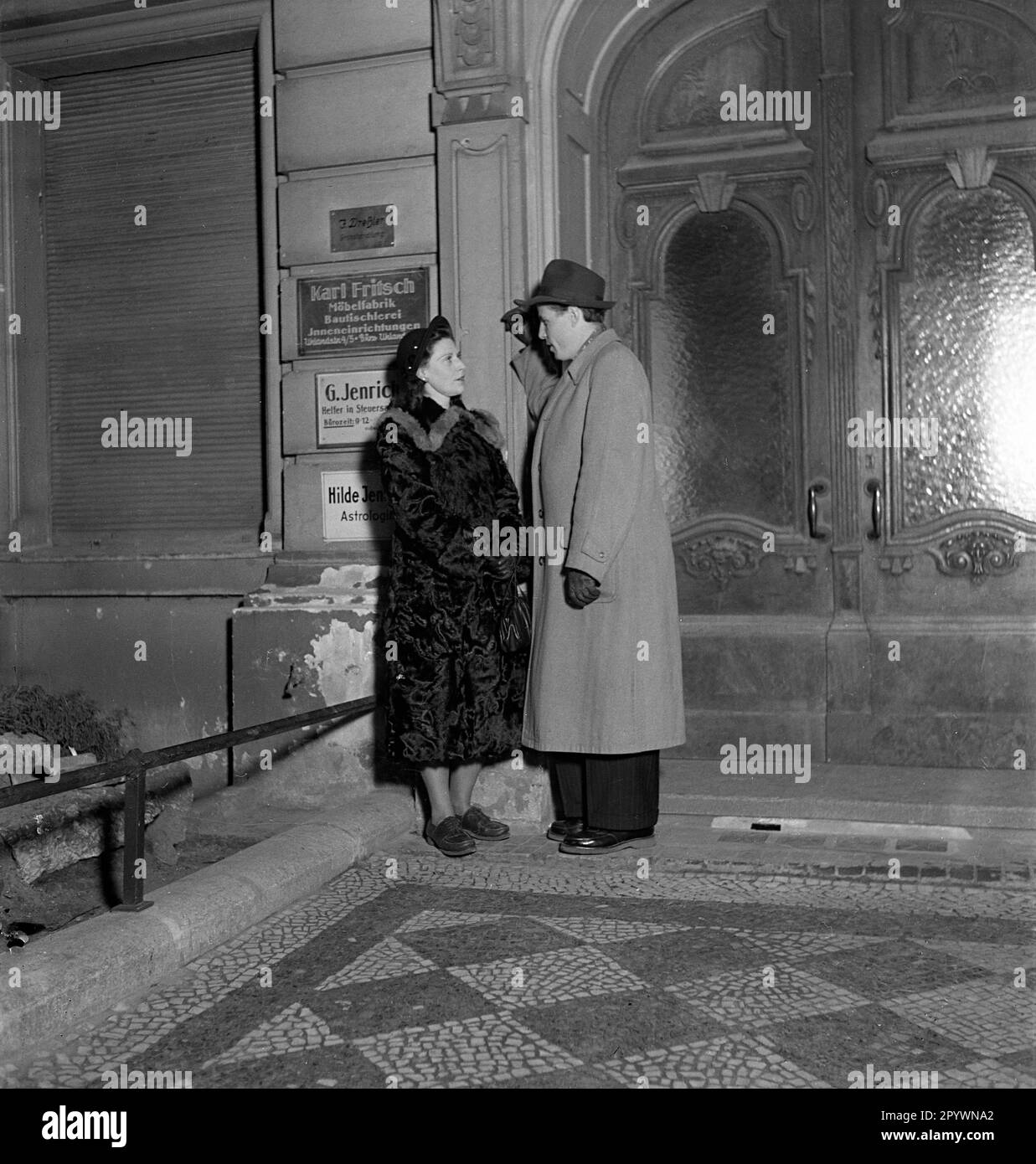 Un uomo e una donna flirt e dire addio a una porta. Foto Stock