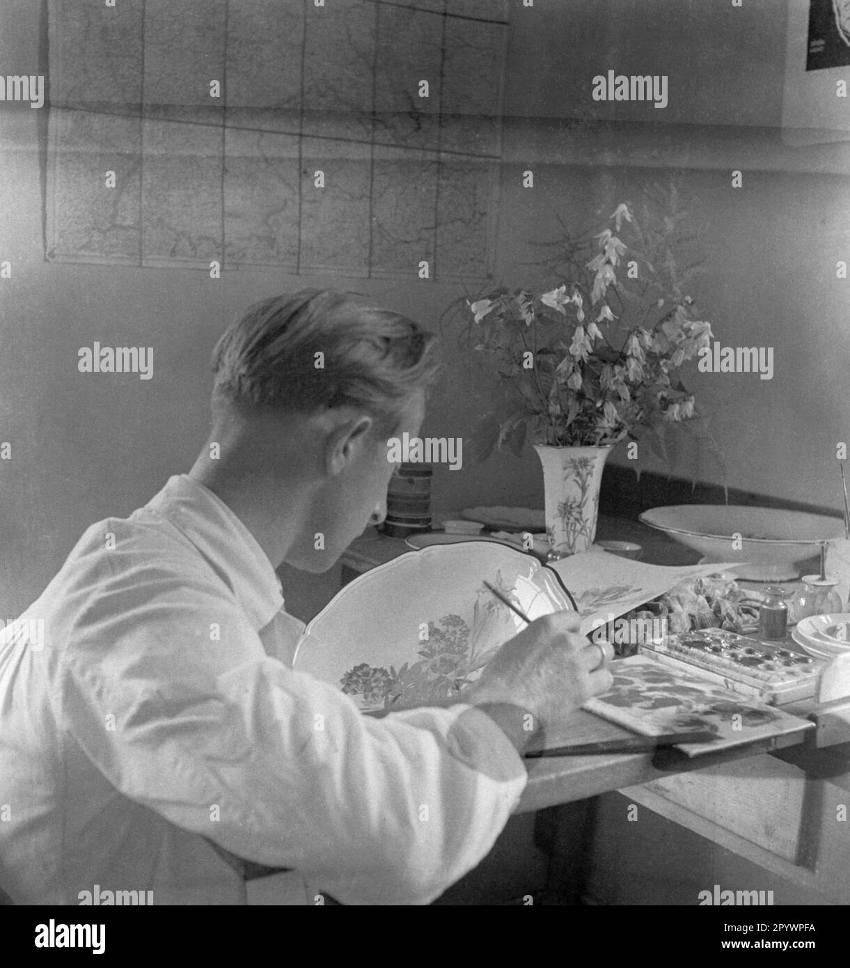 L'uomo dipinge porcellana con fiori selvatici. Foto non datata intorno al 1935 Foto Stock