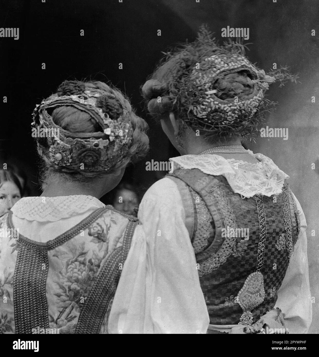 Due donne indossano accessori per capelli coordinati e acconciature intrecciate per i loro costumi. I gioielli per capelli appartengono al costume Berchtesgadener. Foto non datata intorno al 1935. Foto Stock