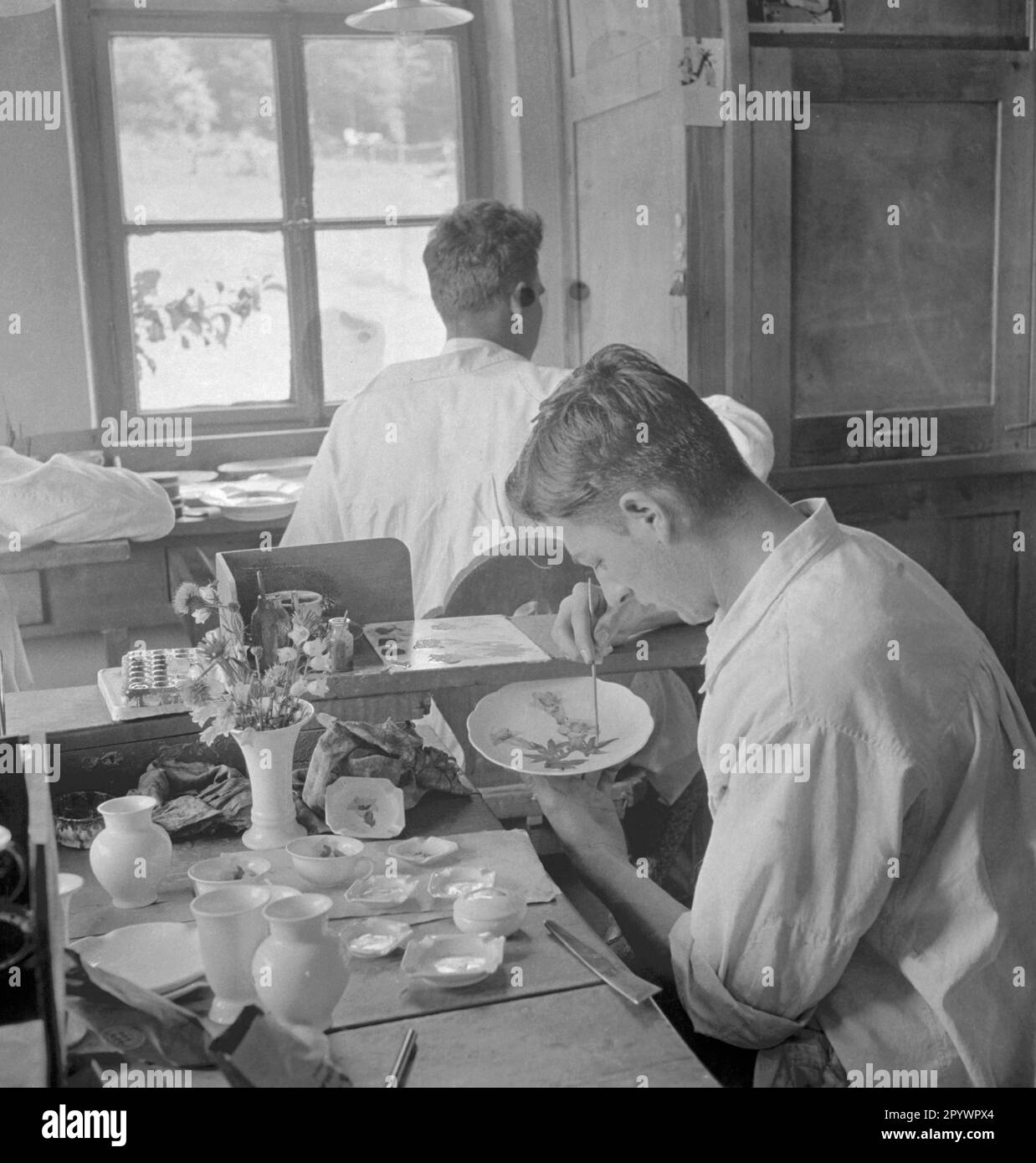 Gli uomini dipingono porcellana con motivi di fiori selvatici. Foto non datata intorno al 1935 Foto Stock