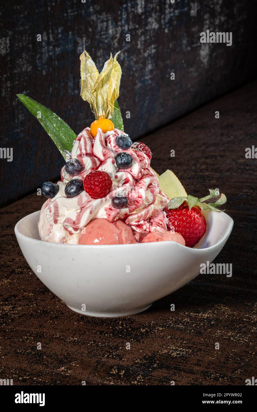 Tazza di gelato alla frutta su sfondo marrone Foto Stock