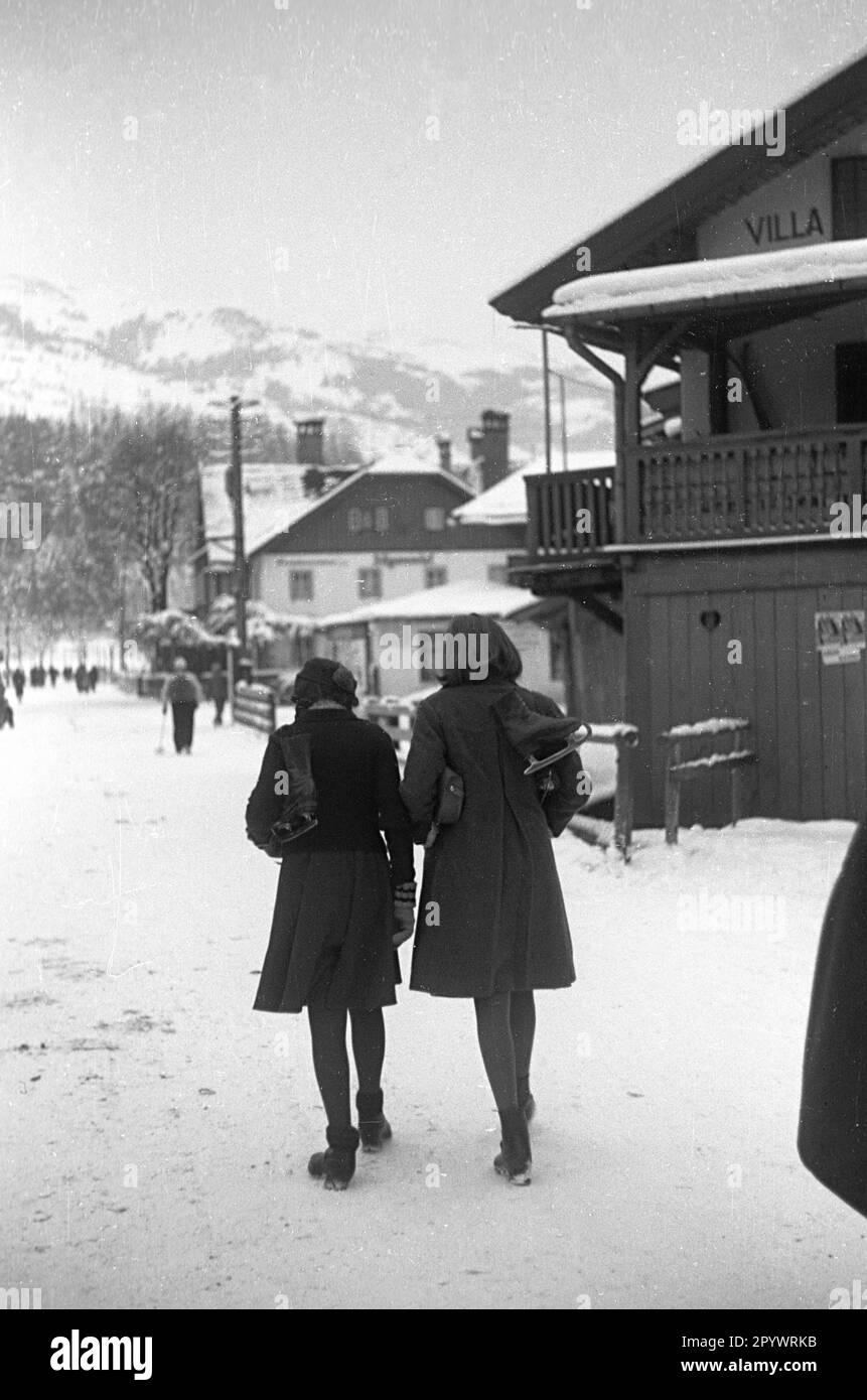 Due giovani donne camminano attraverso St. Johann. I loro pattini sono appesi sopra le loro spalle. Foto non data, probabilmente nell'inverno del 1938/39. Foto Stock
