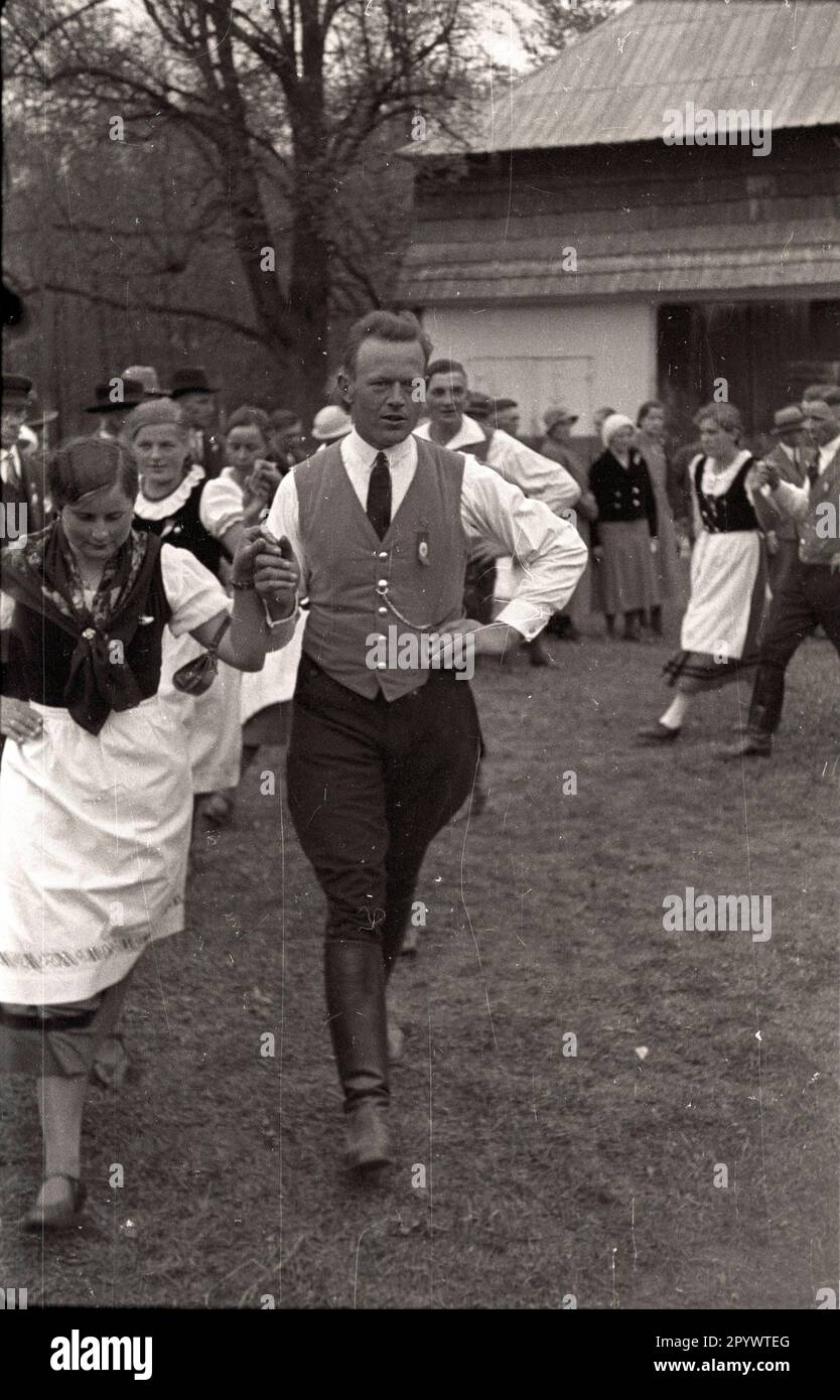 Giovani uomini e donne che ballano in un tradizionale festival di costumi a Wuenschelburg, nella bassa Slesia. L'uomo nella foto indossa un distintivo sul reverlo, probabilmente una svastika. Foto Stock