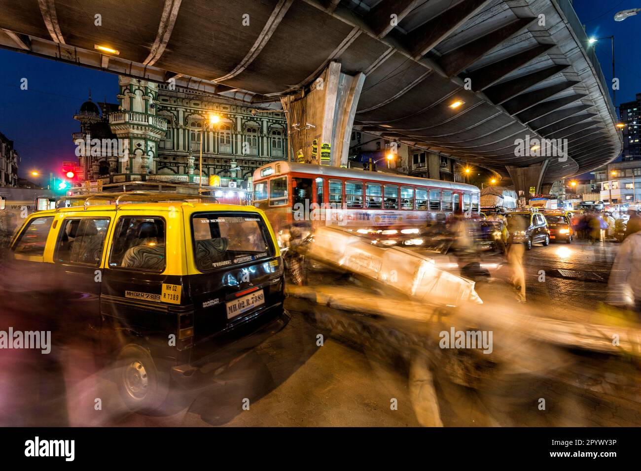 Ora di punta con taxi di fronte alla moschea Minara Majid, vita urbana in serata, vista della città dalle strade del quartiere dominato dai musulmani di Foto Stock