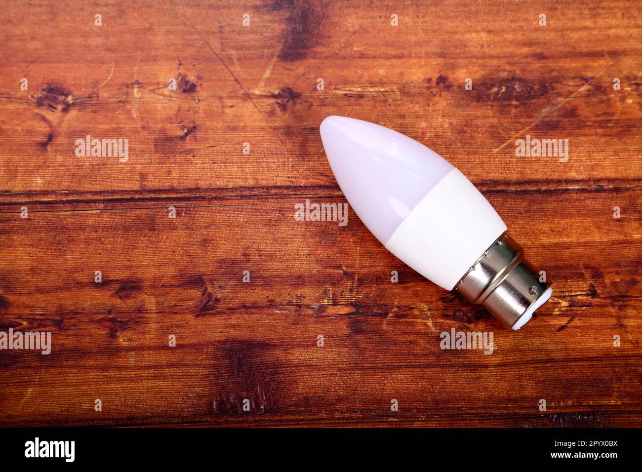 Lampadina a LED a bassa energia appoggiata su un tavolo di legno con spazio copia Foto Stock