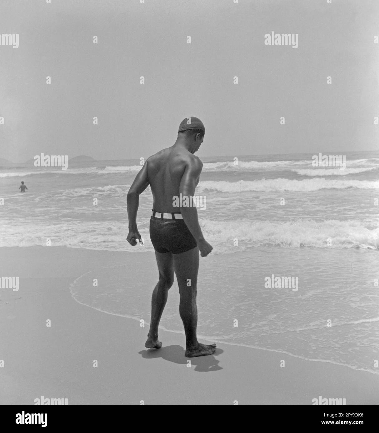 Un uomo brasiliano durante la sua performance acrobatica sulla spiaggia. Foto Stock