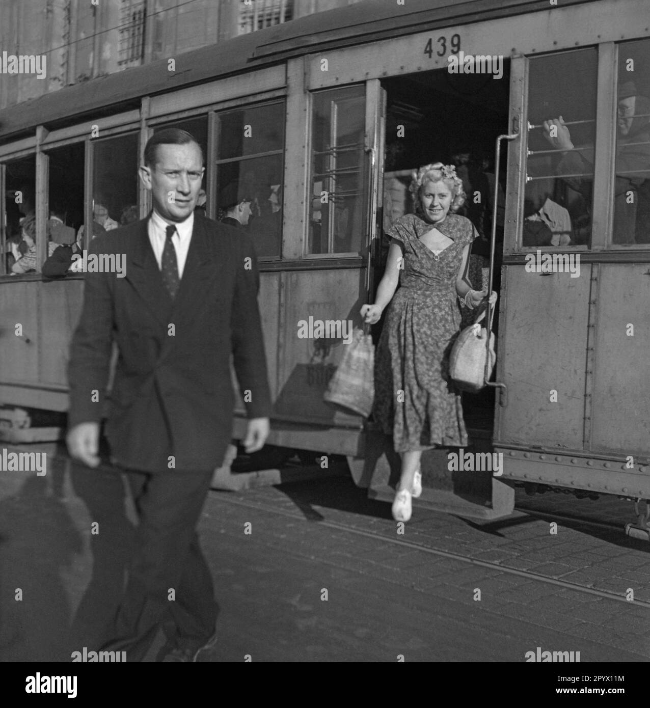 Uomo e donna che escono da un tram a Berlino. Foto Stock