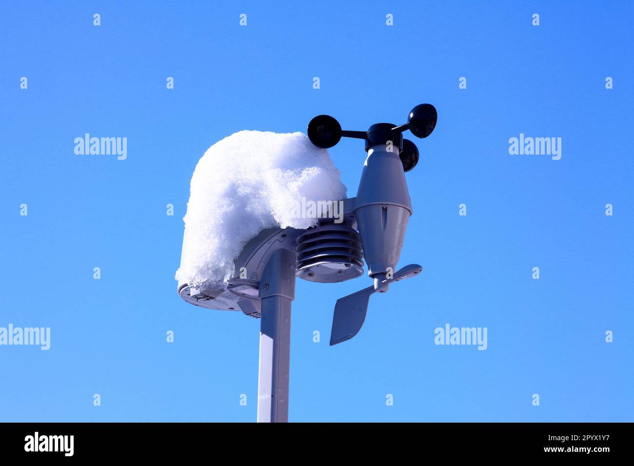 Home stazione meteo sensori esterni coperti di neve contro un cielo blu inverni Foto Stock