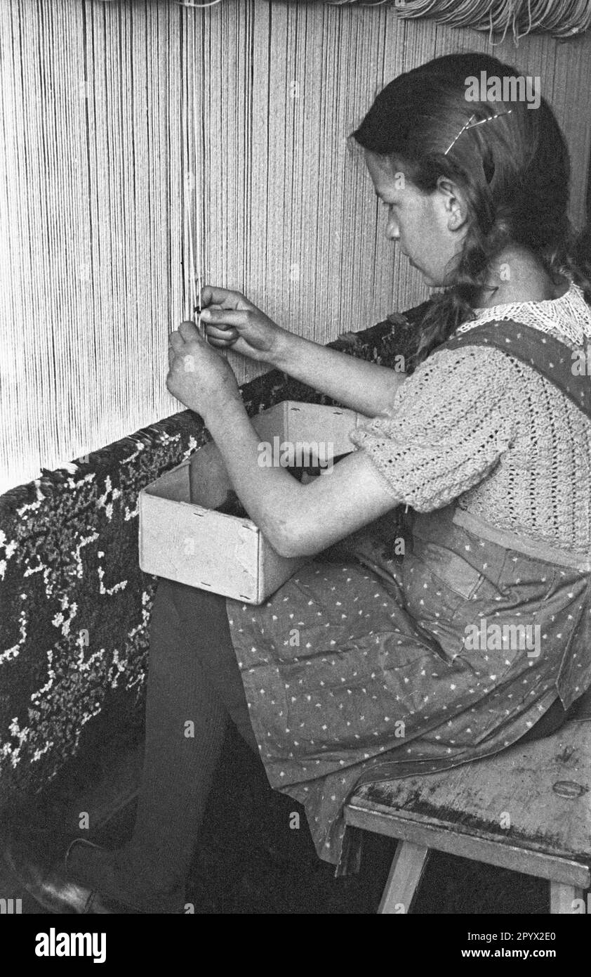 Una ragazza fa un tappeto. È probabilmente una ragazza BDM durante il suo Landfrauenjahr (anno obbligatorio di servizio delle donne in campagna). Vive e lavora in un laboratorio artigianale a Lubmin. La foto è stata scattata nella provincia di Pomerania. Foto Stock