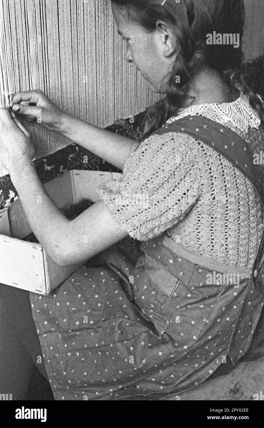 Una ragazza fa un tappeto. È probabilmente una ragazza BDM durante il suo Landfrauenjahr (anno obbligatorio di servizio delle donne in campagna). Vive e lavora in un laboratorio artigianale a Lubmin. La foto è stata scattata nella provincia di Pomerania. Foto Stock