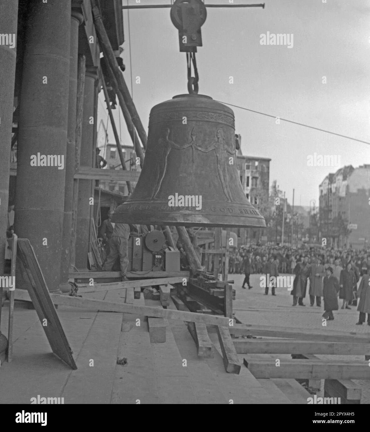 Foto della Campana della libertà su Rathausplatz come viene eretta da una gru da un telaio di legno poco prima della sua installazione nella torre della sede del sindaco di Berlino Ernst Reuter (1948-1953) il 21 ottobre 1950. A sinistra, una delle colonne della porta principale e del ponteggio della torre. Sullo sfondo, soldati degli Stati Uniti Esercito, passanti e giornalisti. Dietro, le case parzialmente distrutte a Badenschen-Strasse e Martin-Luther-Strasse. La campana suonò per la prima volta durante la cerimonia del 24 ottobre, in occasione della Giornata delle Nazioni Unite (ONU). Foto Stock
