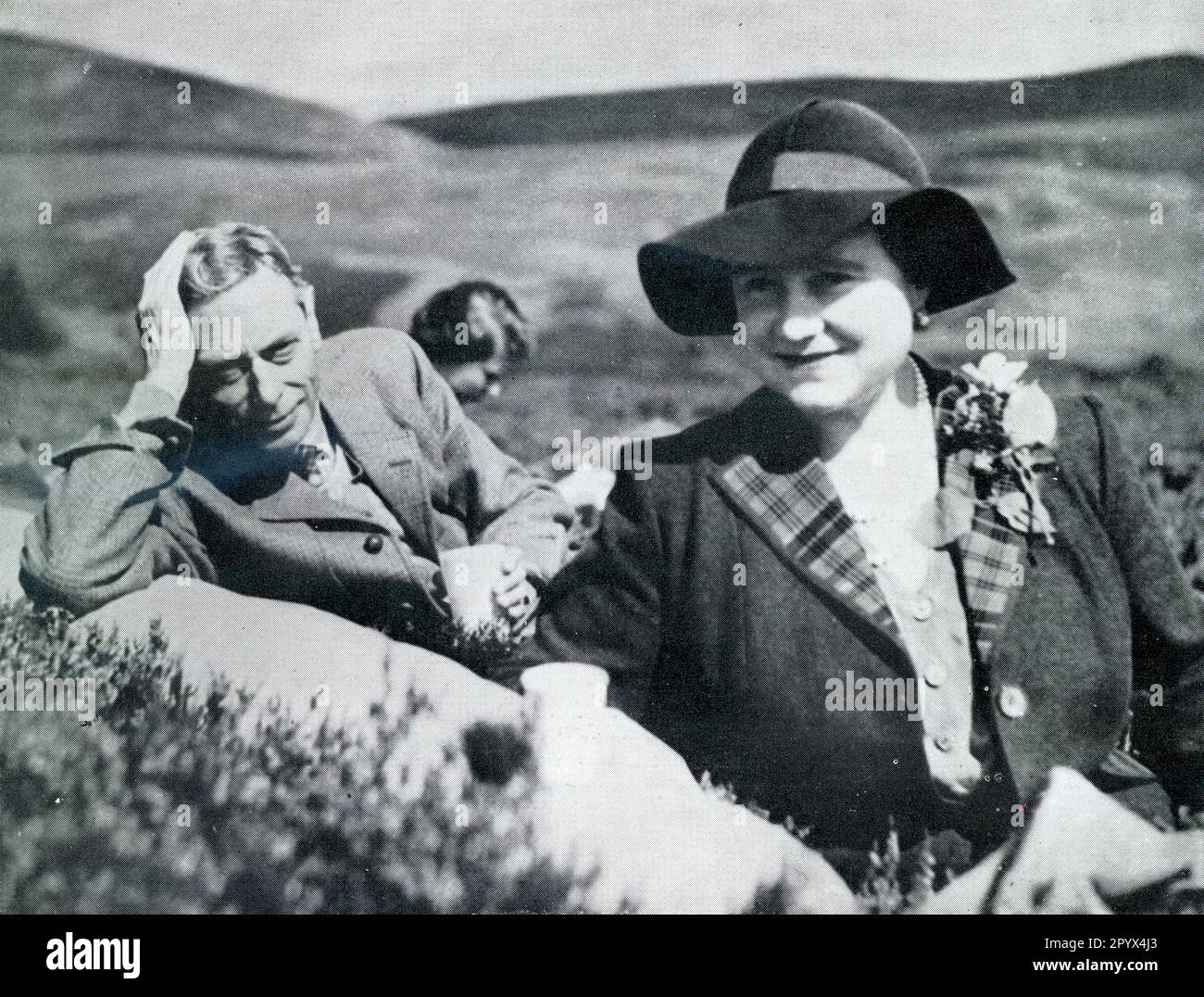 Una rilassata fotografia informale di Re Giorgio VI e Regina Elisabetta (madre della Regina Elisabetta ll - nata Elizabeth Bowes-Lyon) sulle brughiere vicino a Balmoral, Scozia, nell'agosto 1951, pochi mesi prima della morte precoce del Re nel febbraio 1952, di soli 56 anni. La famiglia reale spesso ha avuto picnincs sui fossati quando fuori tiro. La futura regina Elisabetta II si siede alle spalle. Questa fotografia è stata scattata dal conte di Dalkeith, che in seguito divenne il duca di Buccleuch del 9th. Scozia, Regno Unito Foto Stock