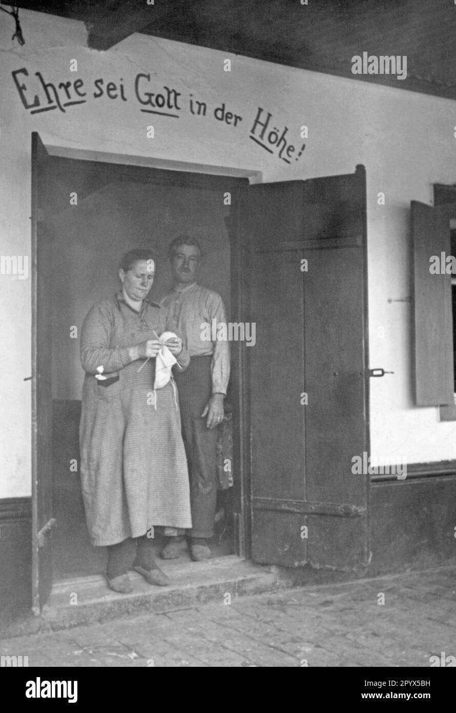 Coppia tedesca nella porta della loro casa. Sopra la porta: Gloria a Dio nel più alto! [traduzione automatica] Foto Stock