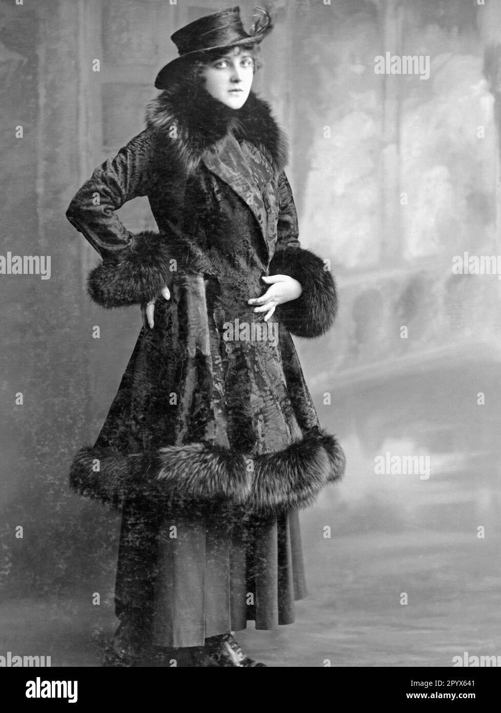 Donna in pelliccia con cappello di velluto rigido con disposizione di piume. [traduzione automatica] Foto Stock