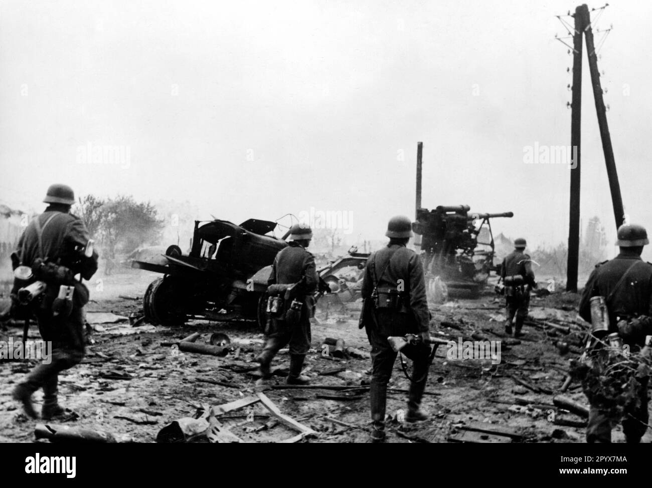 I soldati tedeschi avanzano. In background distrusse le attrezzature da guerra russe. Foto: Knobloch. [traduzione automatica] Foto Stock