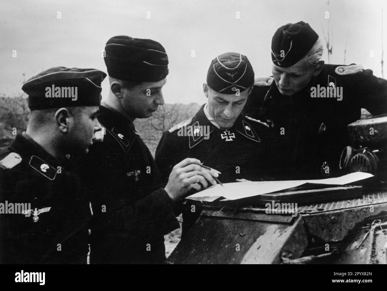 Vincitore di Knight Cross Herbert Gomille, comandante di II Abteilung / Panzer Regiment 4 (13th Panzer Division) parlando con ufficiali della sua divisione vicino Zrau. Foto: Dorfmeister. [traduzione automatica] Foto Stock