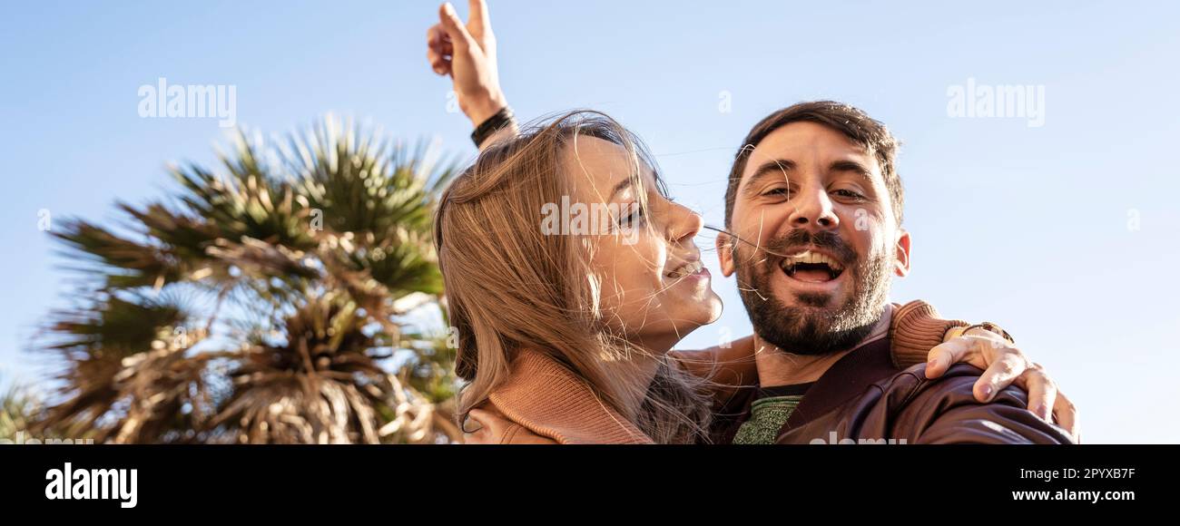 Banner orizzontale o intestazione con giovane coppia hippster che si diverte a scattare un ritratto selfie contro un bellissimo panorama al tramonto. Fidanzata e fidanzata Foto Stock