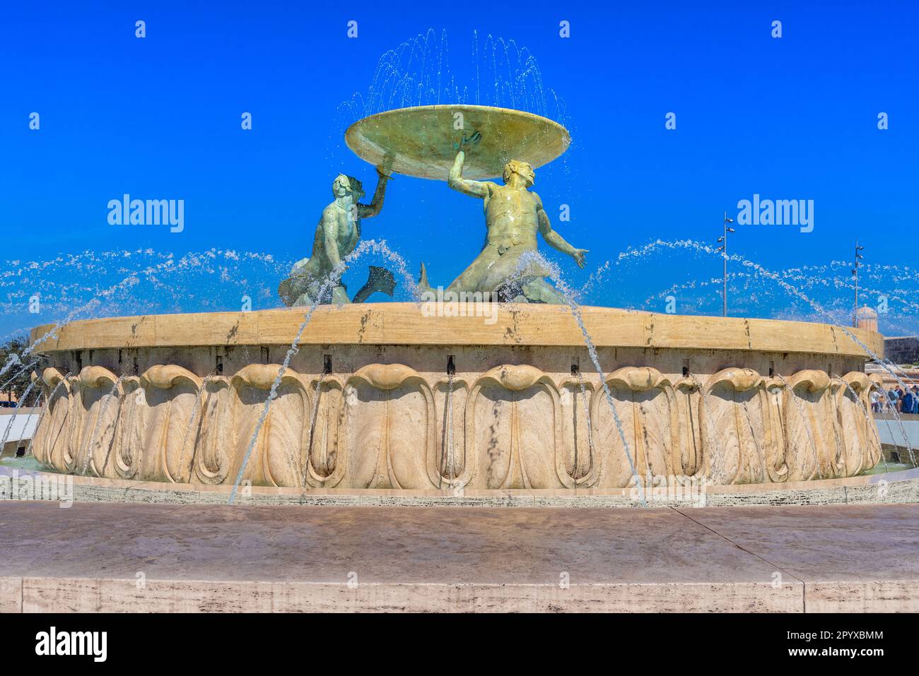 Iconica fontana Tritone di fronte alla porta della città di la Valletta, capitale di Malta Foto Stock