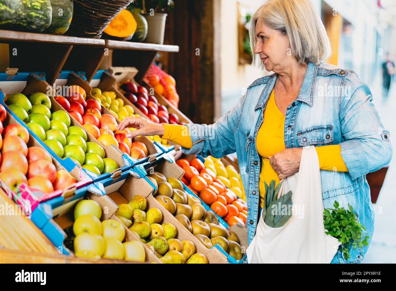 Donna anziana felice che compra frutta fresca al mercato - concetto di cibo di shopping Foto Stock