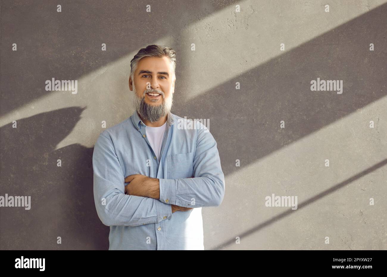 Ritratto di uomo d'affari maturo fiducioso bearded su sfondo grigio parete. Foto Stock