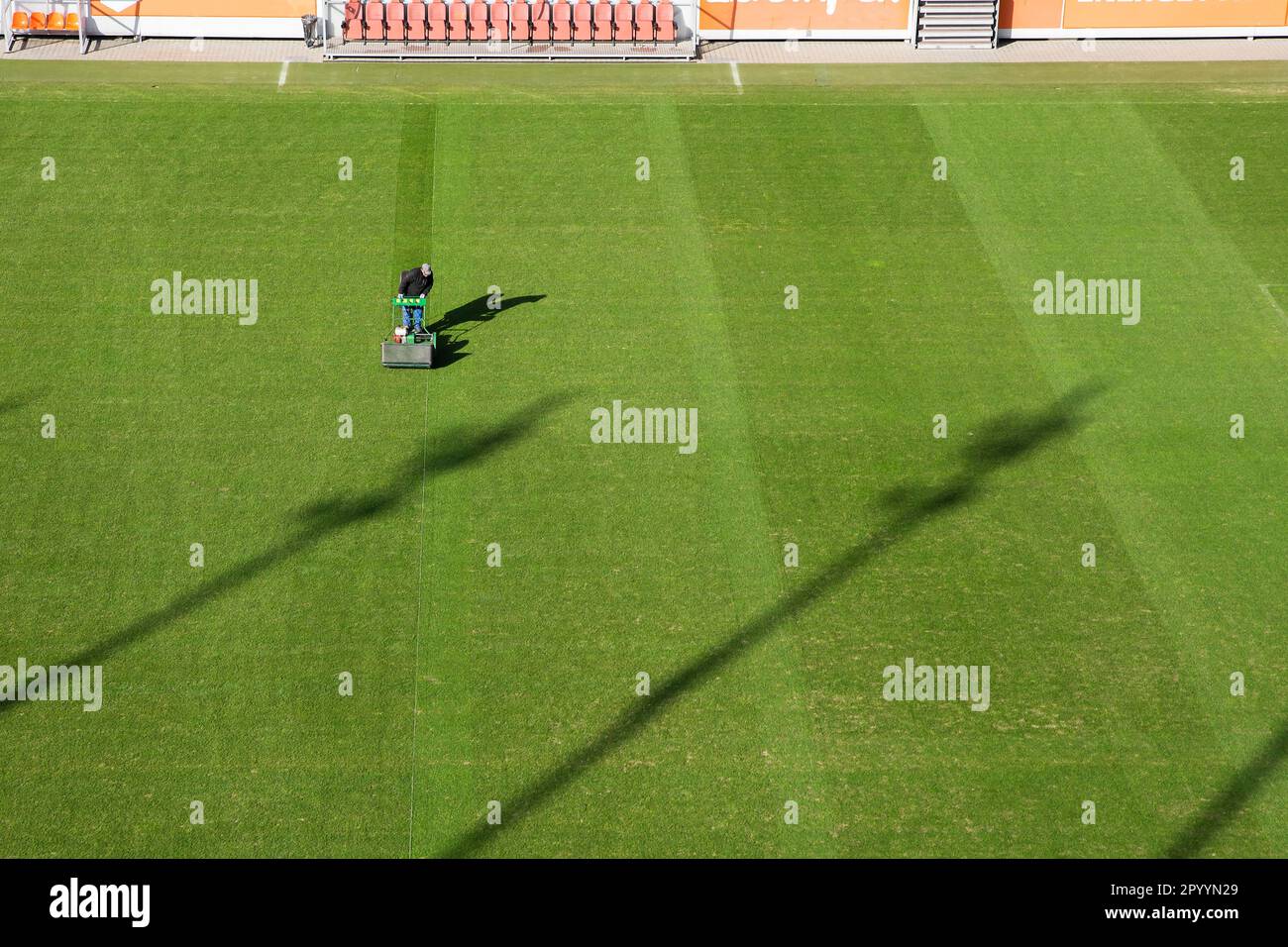 Erba falciante allo stadio di calcio Foto Stock