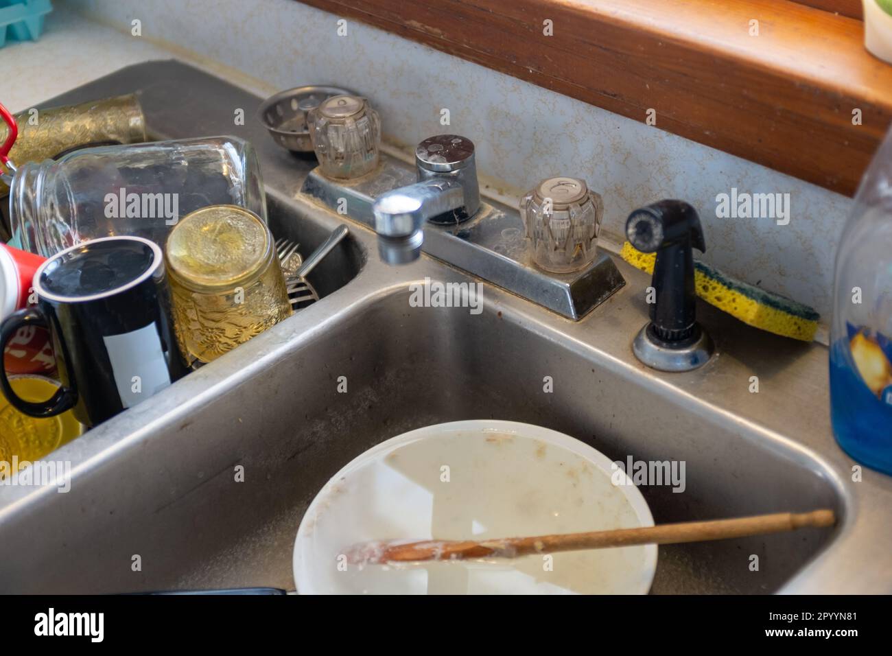piatti sporchi in vecchio lavandino in casa colonica d'epoca Foto Stock