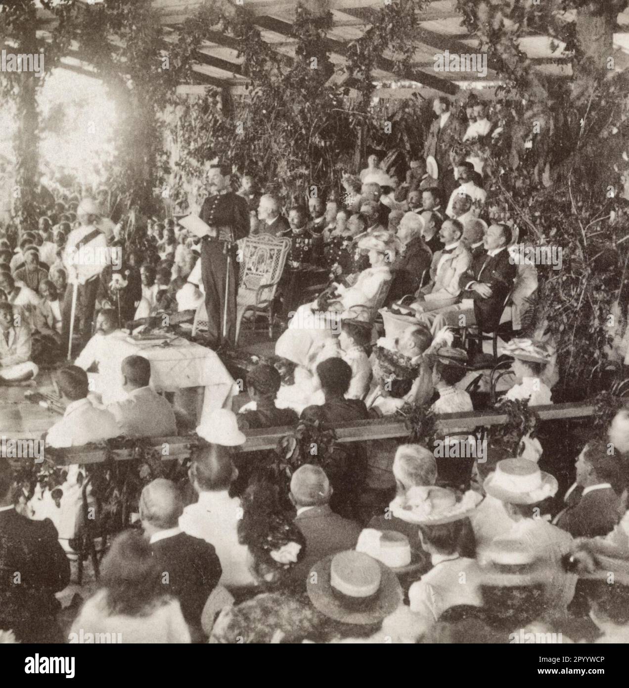 Cerimonie di incoronazione a Suva - consegna del messaggio del re Edoardo, Isole Fiji - ufficiale militare che legge il messaggio del re Edoardo ad un grande gruppo di occidentali e figiani, in occasione della sua incoronazione, intorno al 1902 Foto Stock