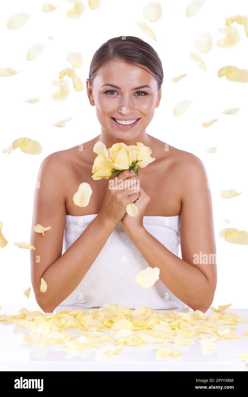 Rose pioventi su una bellezza giovane. Una giovane donna che sorride a voi come petali di rose gialle piovono giù su di lei. Foto Stock