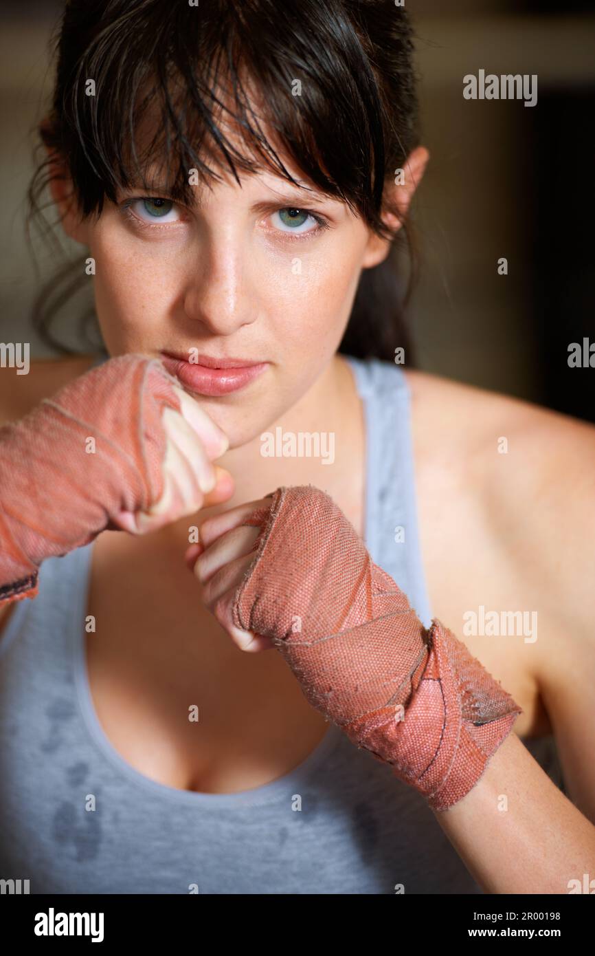 Shell dare tutto il suo. Ritratto di un pugile femminile determinato in piedi pronti a combattere. Foto Stock