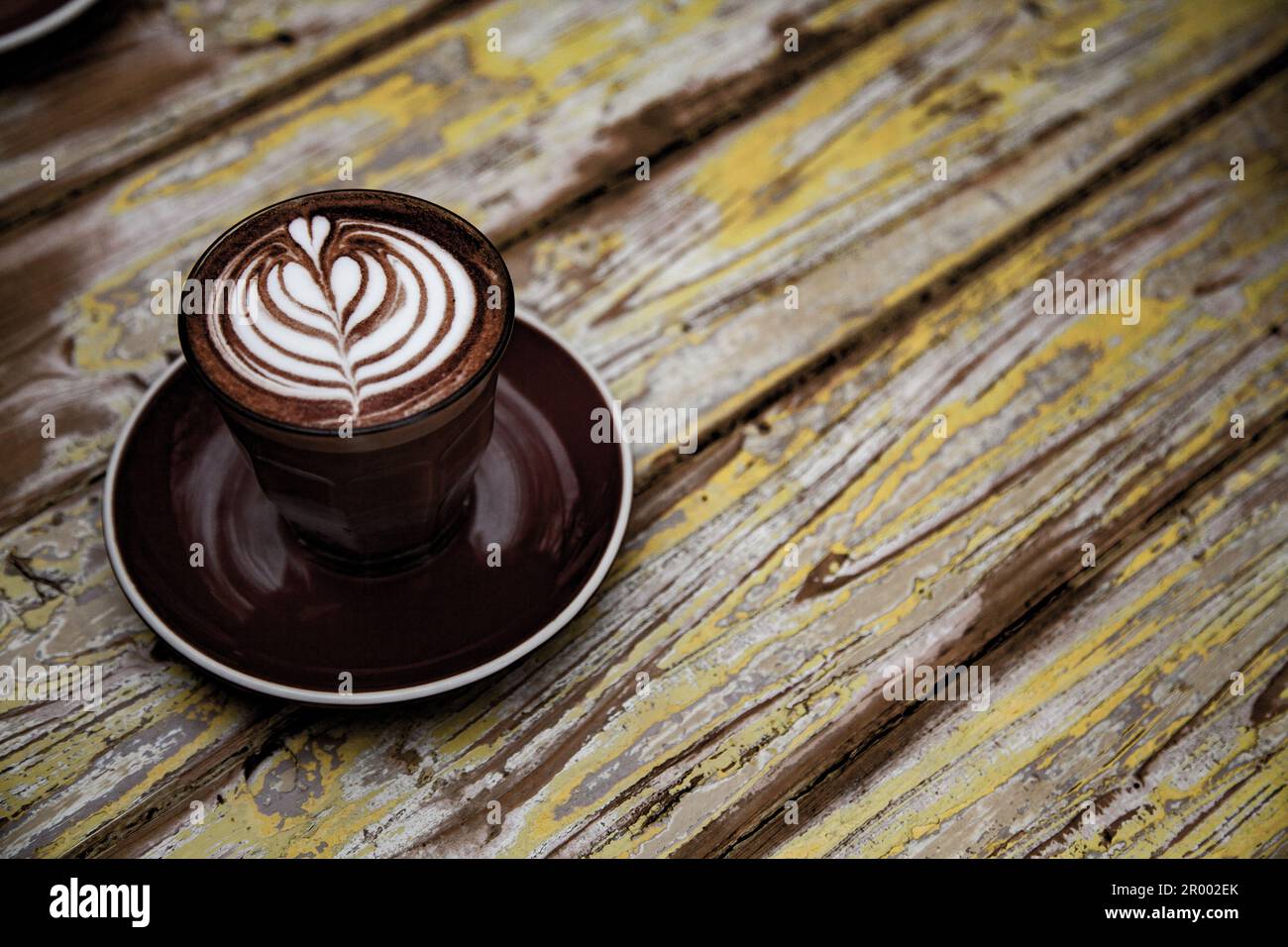 piano in legno di mostarda e marrone al caffè con caffè in tazza Foto Stock
