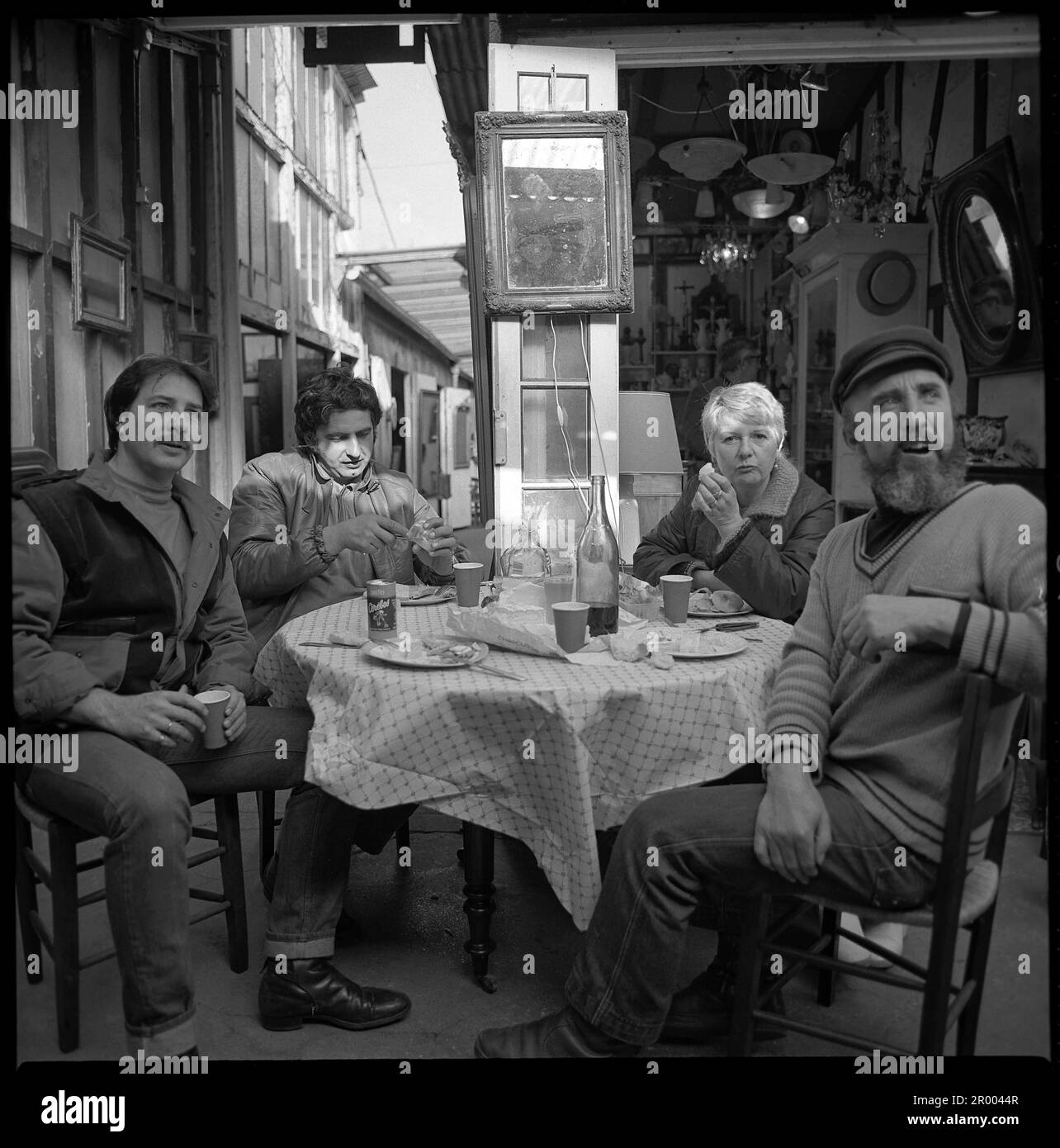 I proprietari di negozi parigini pranzano sul marciapiede. Foto Stock
