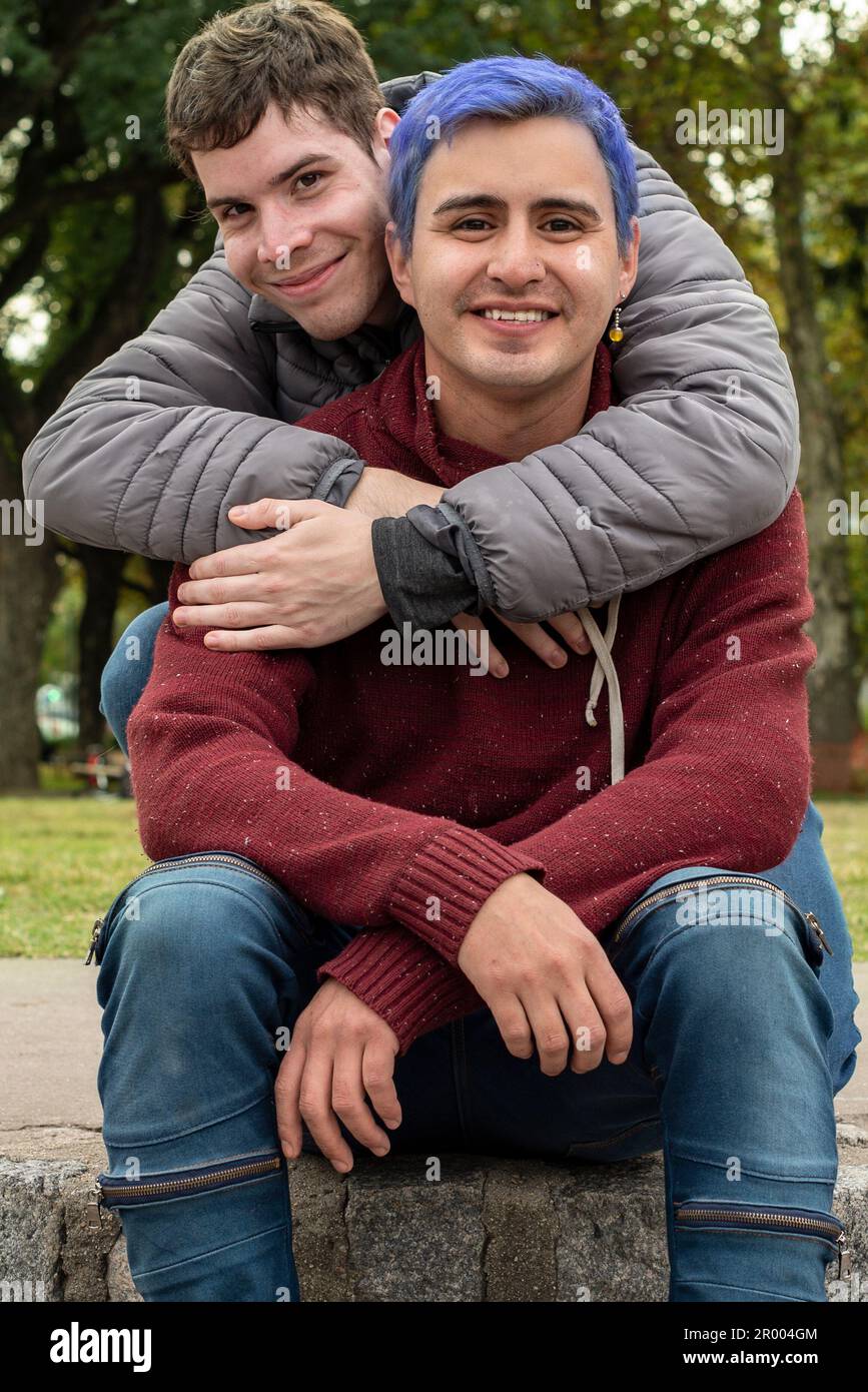 Coppia gay maschio abbraccia e guarda la macchina fotografica all'aperto Foto Stock