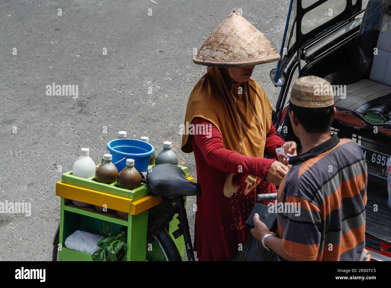 Venditori di medicinali a base di erbe e loro acquirenti. Jamu è una bevanda tradizionale in Indonesia fatta da vari tipi di spezie e piante. Foto Stock