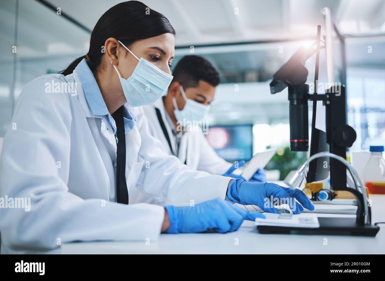 Un po' di duro lavoro potrebbe fare la differenza. due giovani ricercatori che utilizzano dispositivi digitali in un laboratorio. Foto Stock
