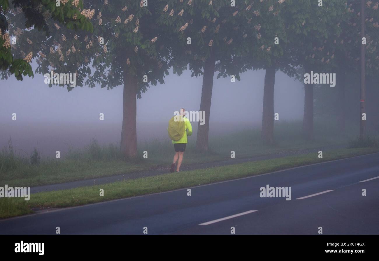 Bornheim, Germania. 06th maggio, 2023. Un pareggiatore corre accanto ad una strada vicino a Bornheim nella foschia mattutina. Credit: Thomas Banneyer/dpa/Alamy Live News Foto Stock