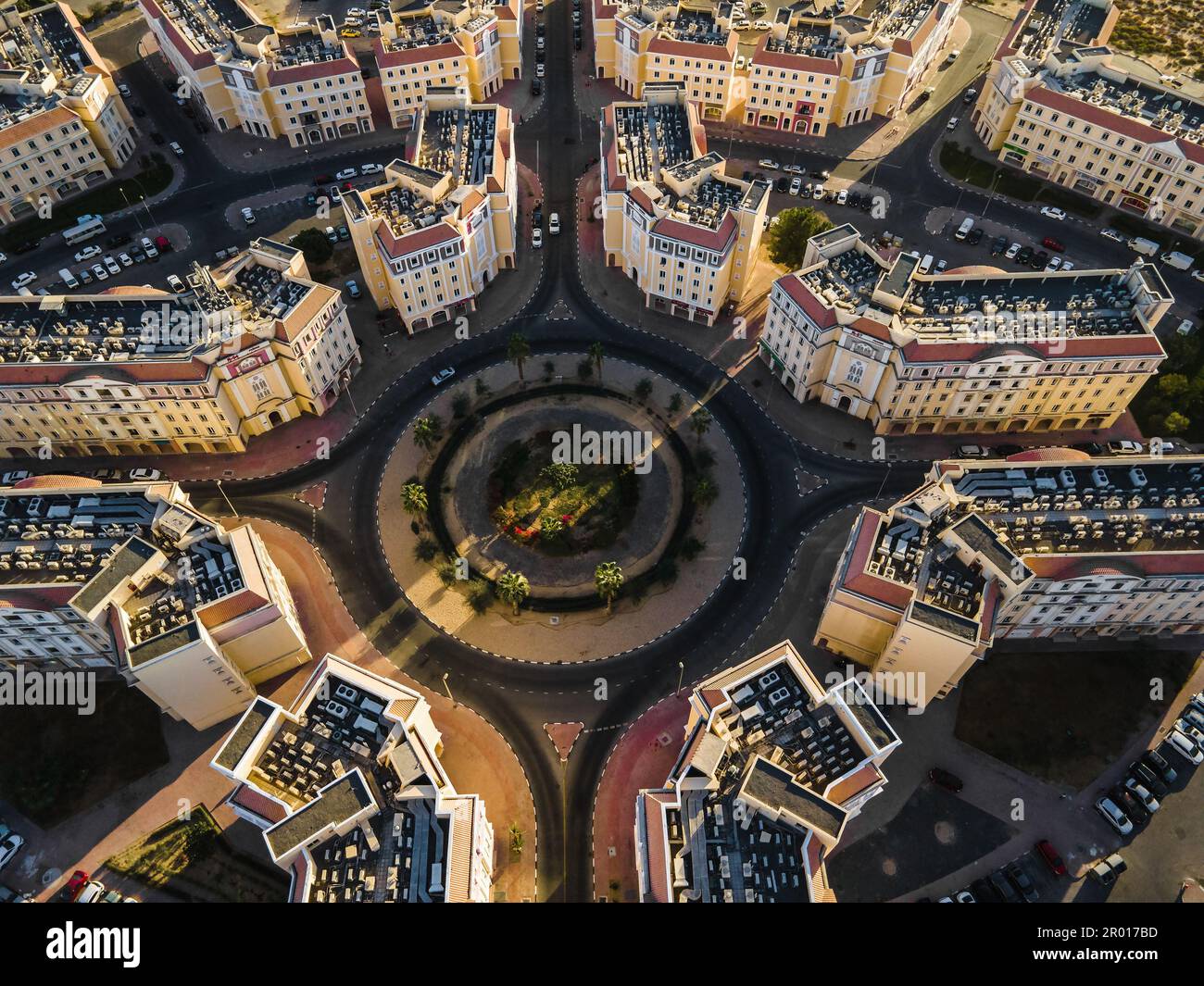 Rotonda e simmetria architettonica di International City a Dubai, Emirati Arabi Uniti. Architettura suburbana a tema country di residenze nel Foto Stock