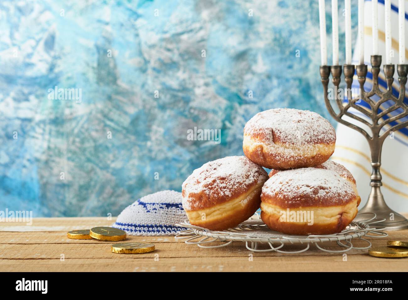 Hanukkah felice. Hanukkah vecchio Menorah sullo sfondo della bandiera israeliana con luce solare o bokeh su sfondo di legno bianco. Immagine religiosa dei gioielli Foto Stock