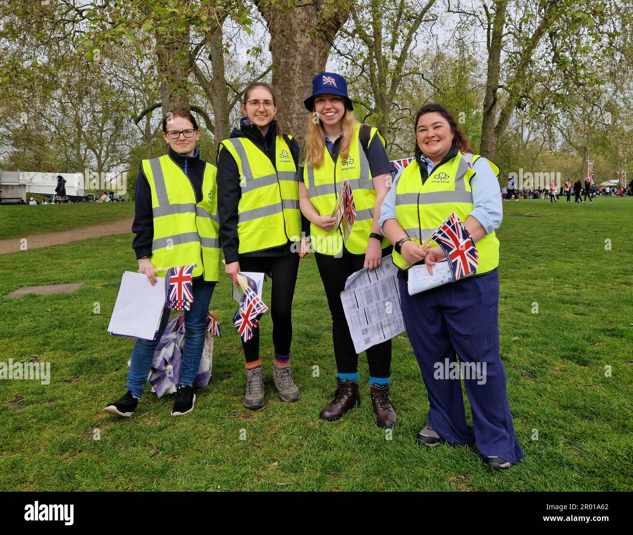 Londra, Regno Unito. 06th maggio, 2023. Abbie (l-r), Holly, Daisy e Becca si dedicano al St James' Park fornendo bandiere e aiutando con le informazioni. Fanno parte dell'organizzazione Girlguiding, o Girl Scout. Sono orgogliosi di essere presenti per il grande giorno. "È un'esperienza unica nella vita", afferma Holly. Nonostante i loro doveri, le giovani donne sperano di vedere un po' della processione. Numerosi ospiti sono attesi a Londra per l'incoronazione di Re Carlo III Credit: Larissa Schwedes/dpa/Alamy Live News Foto Stock