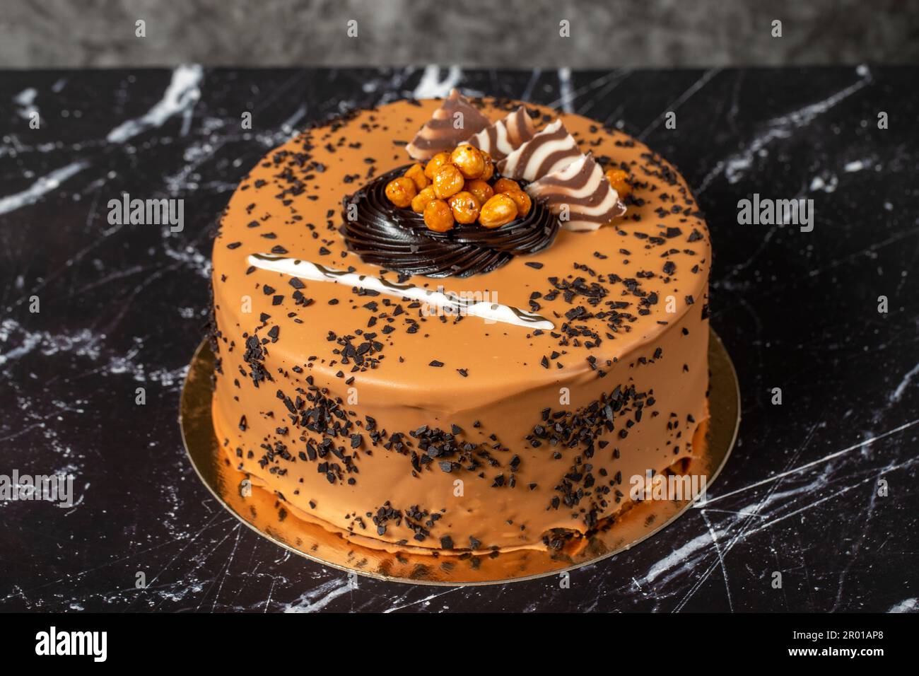 Torta di crema al caramello. Torta di compleanno o di festa. Torta con caramello e crema al cioccolato su fondo scuro. Foto Stock