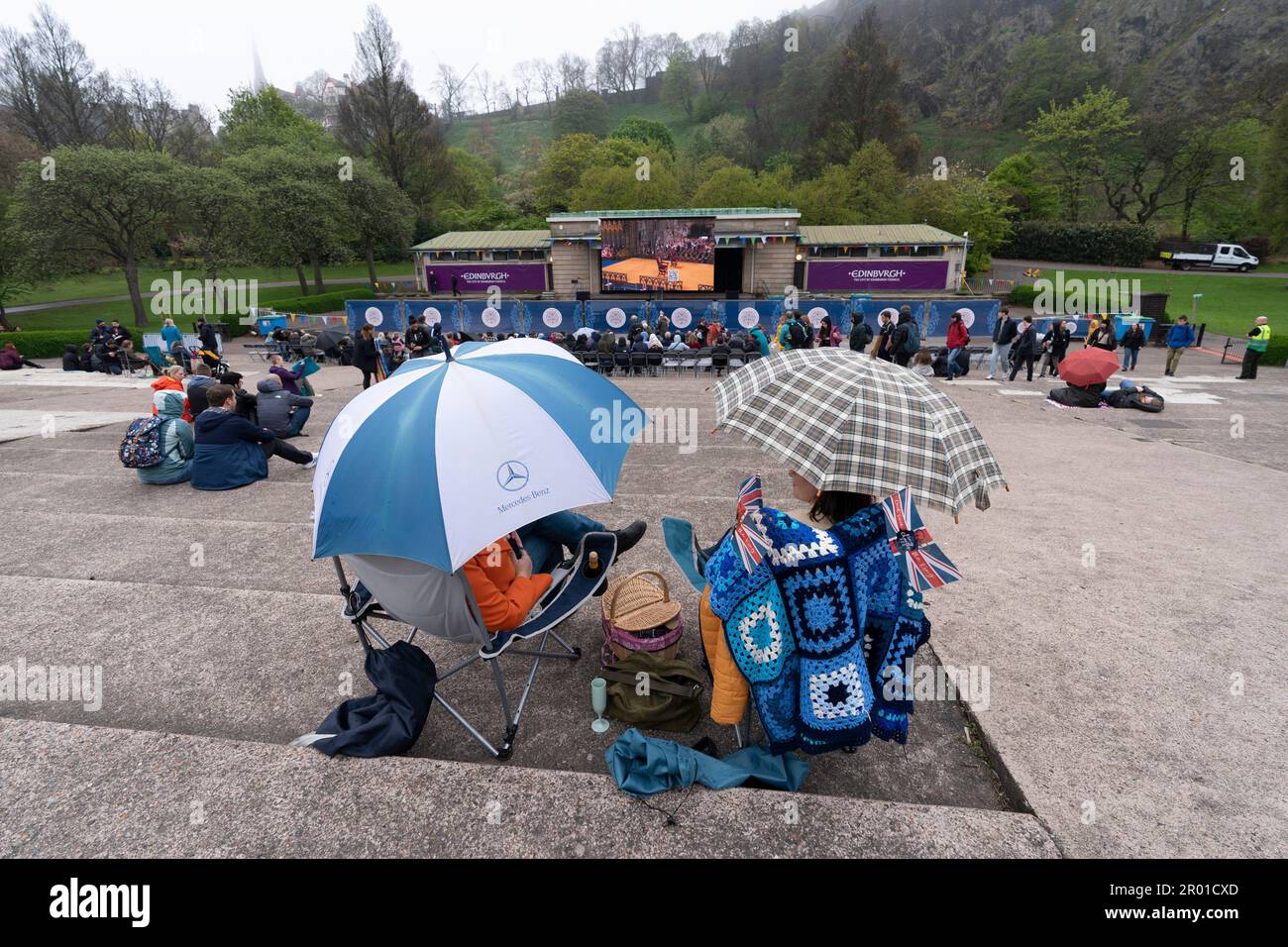 Edimburgo, Scozia, Regno Unito. 6 maggio 2023. Scene da Edimburgo il giorno dell'incoronazione di re Carlo III I membri del pubblico si sono preparati per il tempo umido nei West Princes Street Gardens, dove è stato eretto un grande schermo televisivo. Iain Masterton/Alamy Live News Foto Stock