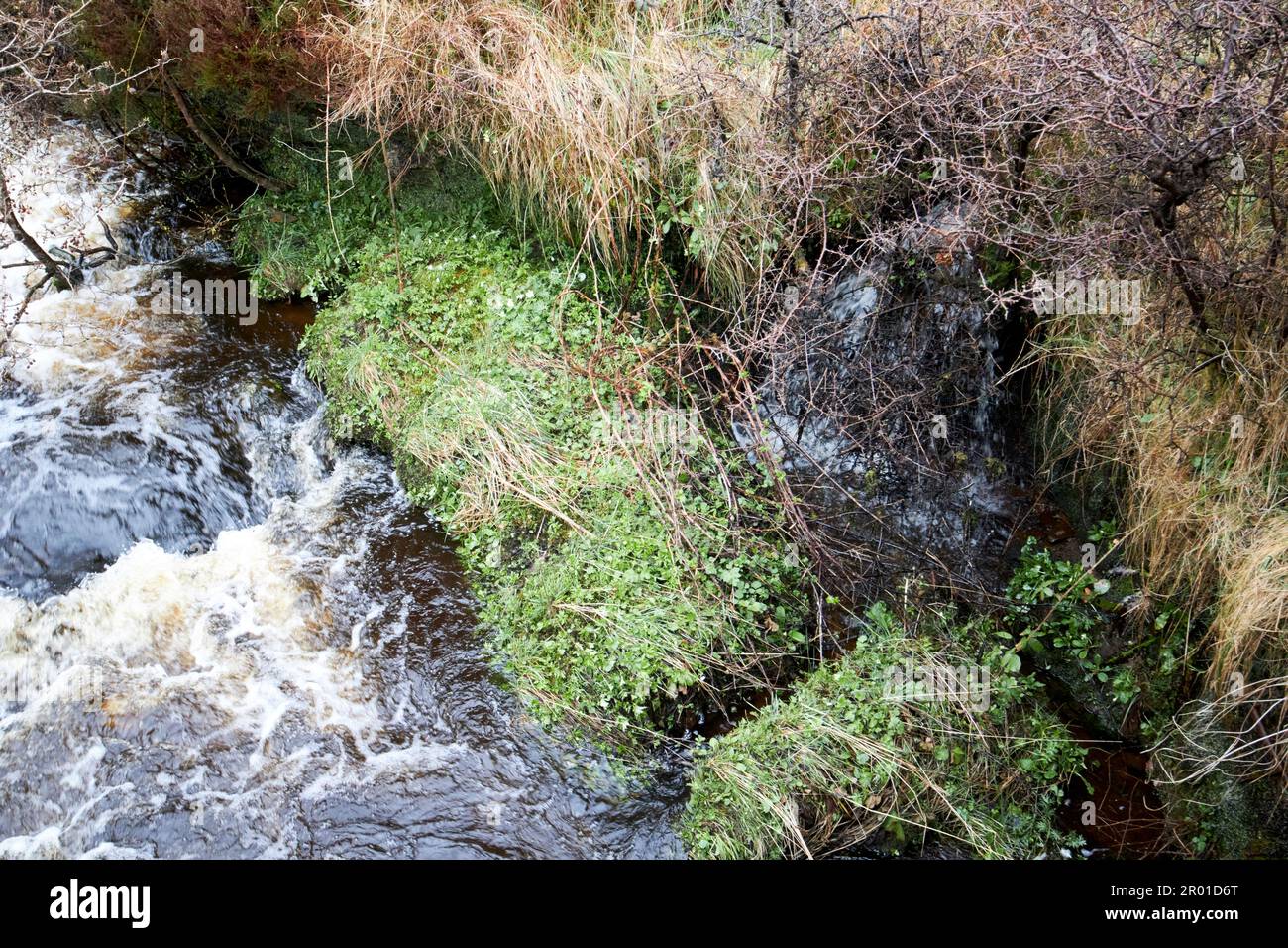 fosso di drenaggio di campo che fluisce in piccolo fiume di ruscello in alluvione nella regione rurale remota di montagna della contea donegal repubblica d'irlanda Foto Stock