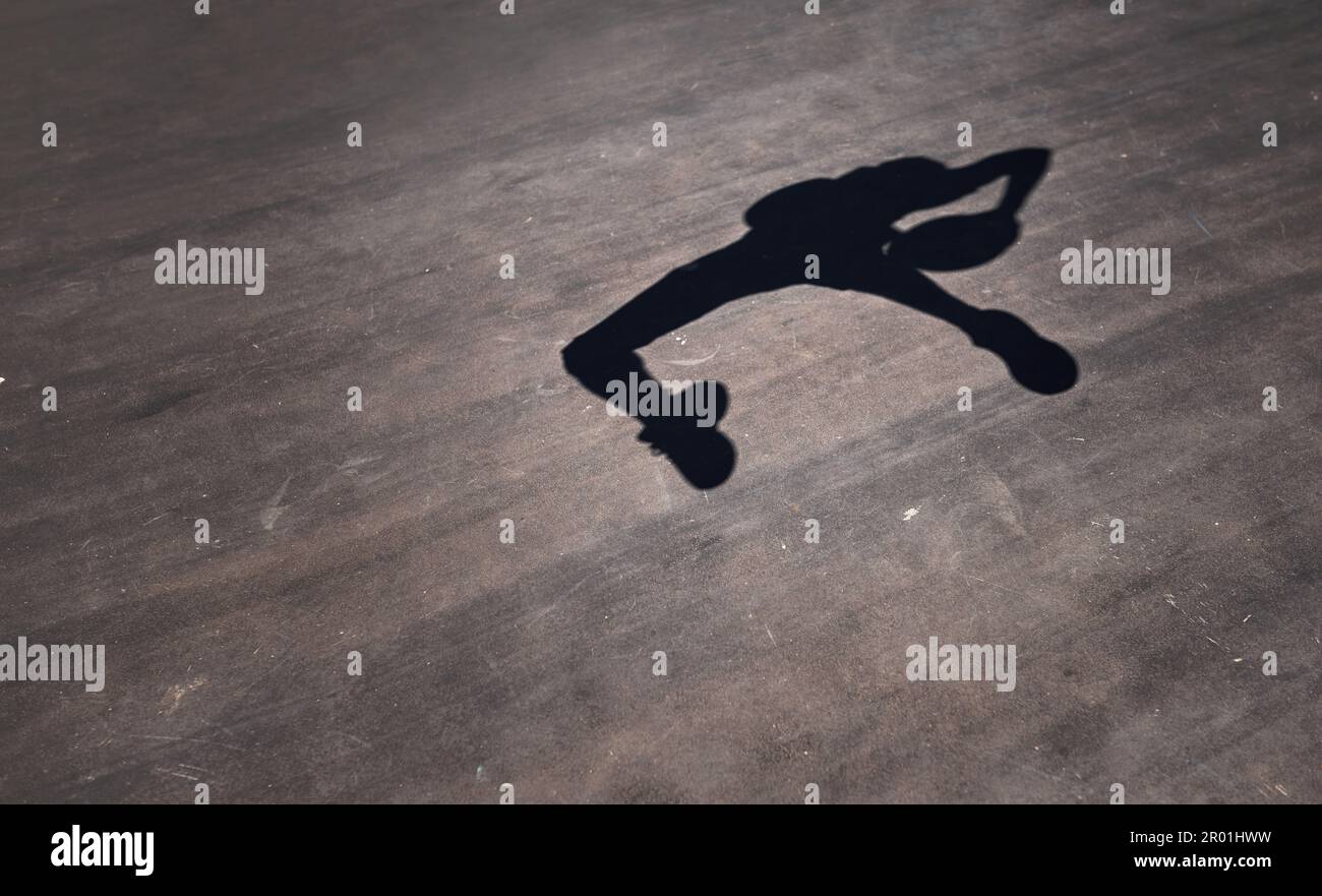 Salta, ruota e gira verso l'anello. l'ombra di un uomo che lancia un basket su un campo sportivo. Foto Stock