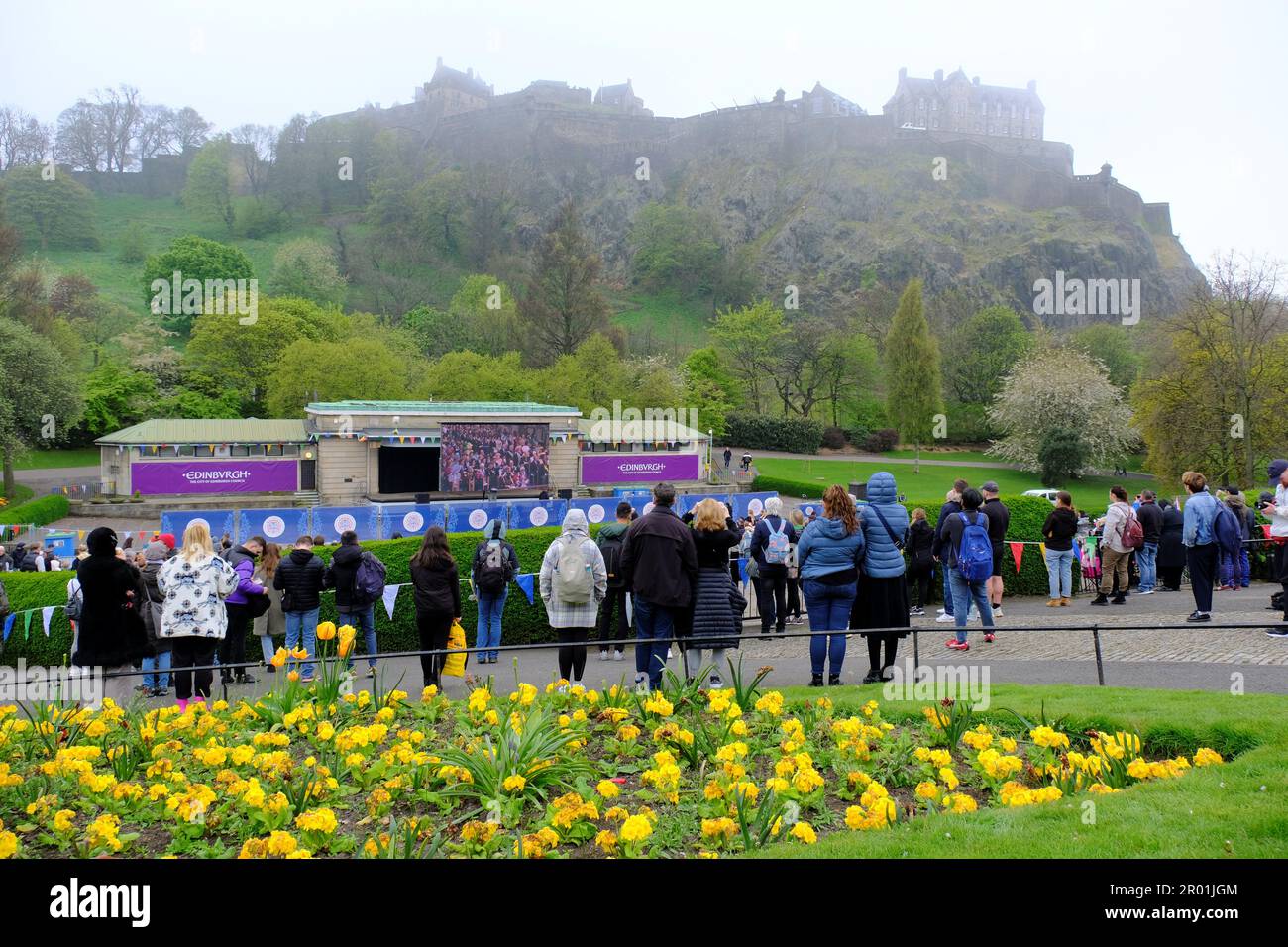 Edimburgo, Scozia, Regno Unito. 6th maggio 2023. Una visione dal vivo dell'incoronazione di Re Carlo III su un grande schermo presso il Ross Bandstand nei West Princes Street Gardens con uno sfondo del Castello di Edimburgo. Credit: Craig Brown/Alamy Live News Foto Stock