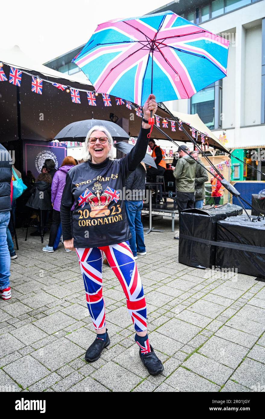 Brighton UK 6th maggio 2023 - Uno spettatore vestito sotto la pioggia mentre la folla guarda l'incoronazione di re Carlo III in un grande schermo allestito oggi a Brighton's Jubilee Square : Credit Simon Dack / Alamy Live News Foto Stock Brighton UK 6th maggio 2023 - Uno spettatore vestito sotto la pioggia mentre la folla guarda l'incoronazione di re Carlo III in un grande schermo allestito oggi a Brighton's Jubilee Square : Credit Simon Dack / Alamy Live News Foto Stock