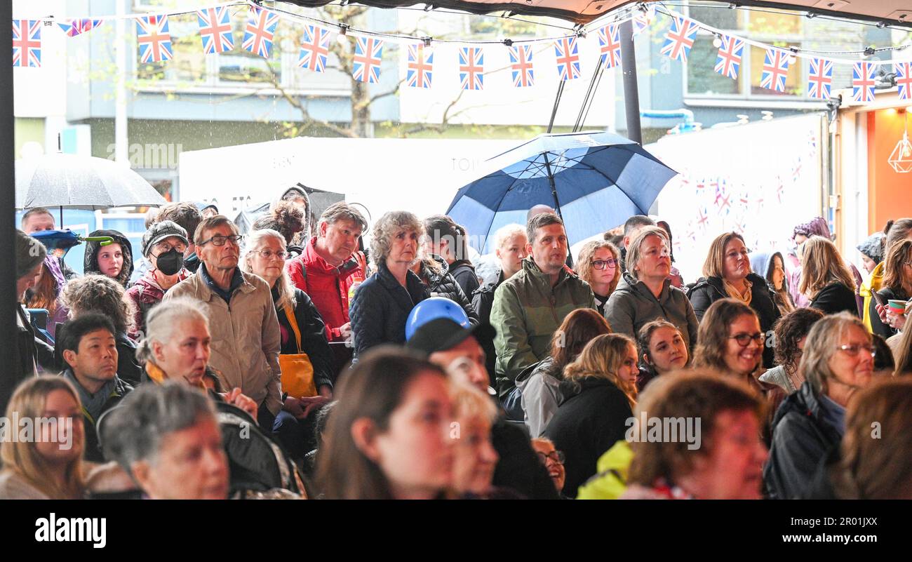 Brighton UK 6th maggio 2023 - le folle guardano l'incoronazione di Re Carlo III a un grande schermo in Brighton's Jubilee Square oggi : Credit Simon Dack / Alamy Live News Foto Stock