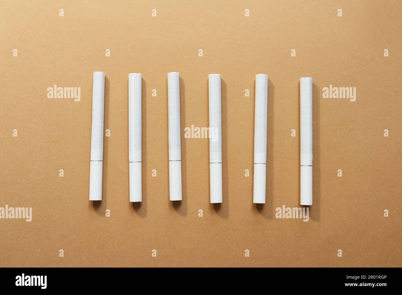 Wheres un più leggero quando ne avete bisogno. Studio shot di una fila di sigarette su uno sfondo marrone. Foto Stock