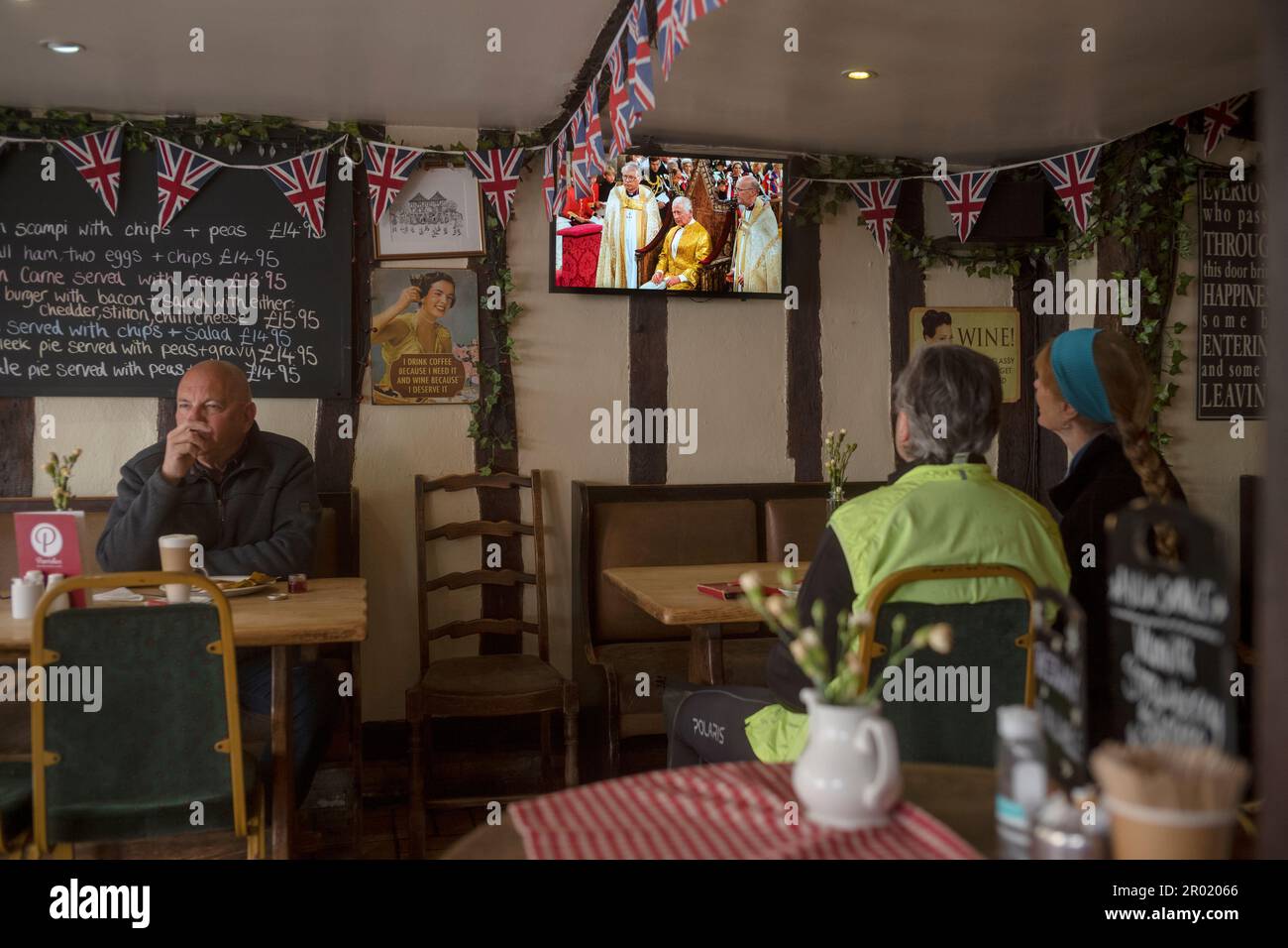 Thaxted, Inghilterra Regno Unito GB. 06th maggio, 2023. Incoronazione Re Carlo III Thaxted Essex UK 6 Maggio 2023 l'incoronazione di Re Carlo III e Regina Camilla all'Abbazia di Westminster a Londra, come visto in televisione al Parrishes Wine Bar di Thaxted nel Nord Essex, Inghilterra. Fotografia di credito: BRIAN HARRIS/Alamy Live News Foto Stock