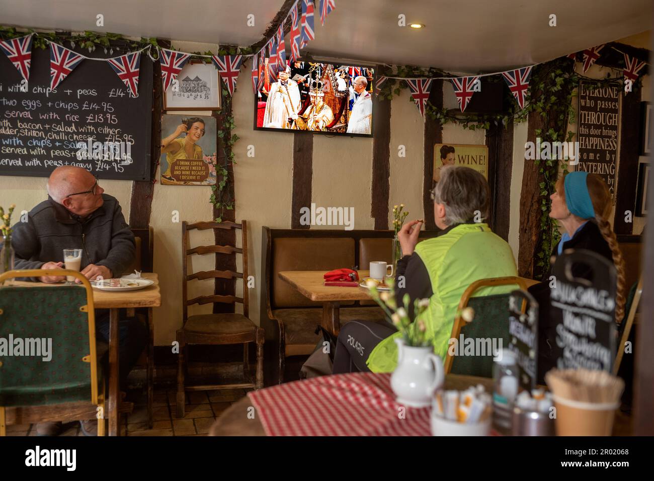 Thaxted, Inghilterra Regno Unito GB. 06th maggio, 2023. Incoronazione Re Carlo III Thaxted Essex UK 6 Maggio 2023 l'incoronazione di Re Carlo III e Regina Camilla all'Abbazia di Westminster a Londra, come visto in televisione al Parrishes Wine Bar di Thaxted nel Nord Essex, Inghilterra. Fotografia di credito: BRIAN HARRIS/Alamy Live News Foto Stock
