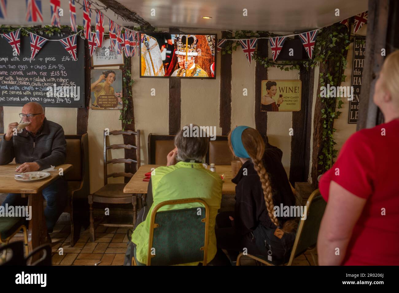 Thaxted, Inghilterra Regno Unito GB. 06th maggio, 2023. Incoronazione Re Carlo III Thaxted Essex UK 6 Maggio 2023 l'incoronazione di Re Carlo III e Regina Camilla all'Abbazia di Westminster a Londra, come visto in televisione al Parrishes Wine Bar di Thaxted nel Nord Essex, Inghilterra. Fotografia di credito: BRIAN HARRIS/Alamy Live News Foto Stock